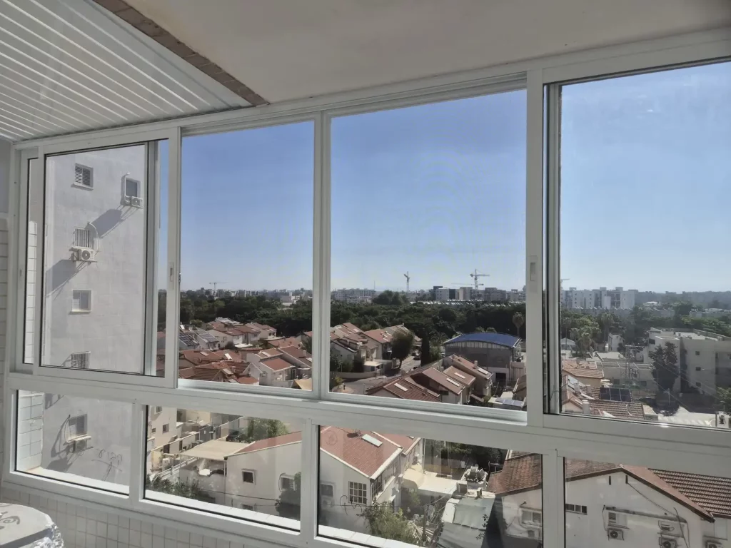 סגירת חורף מאלומיניום לבן למרפסת עם נוף פתוח