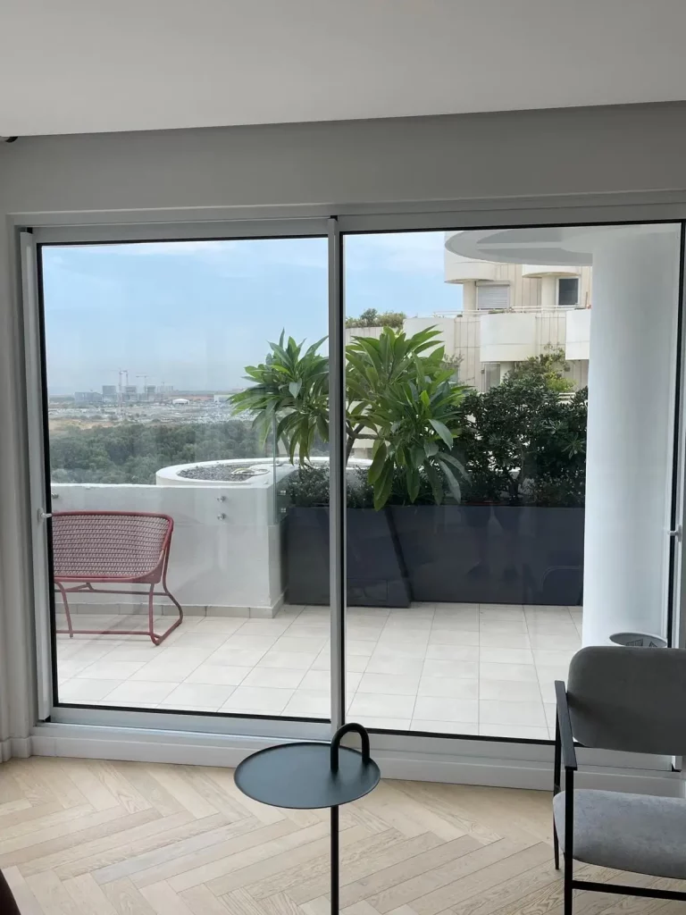 דלת הזזה מאלומיניום שחורה ליציאה למרפסת גג עם נוף פתוח