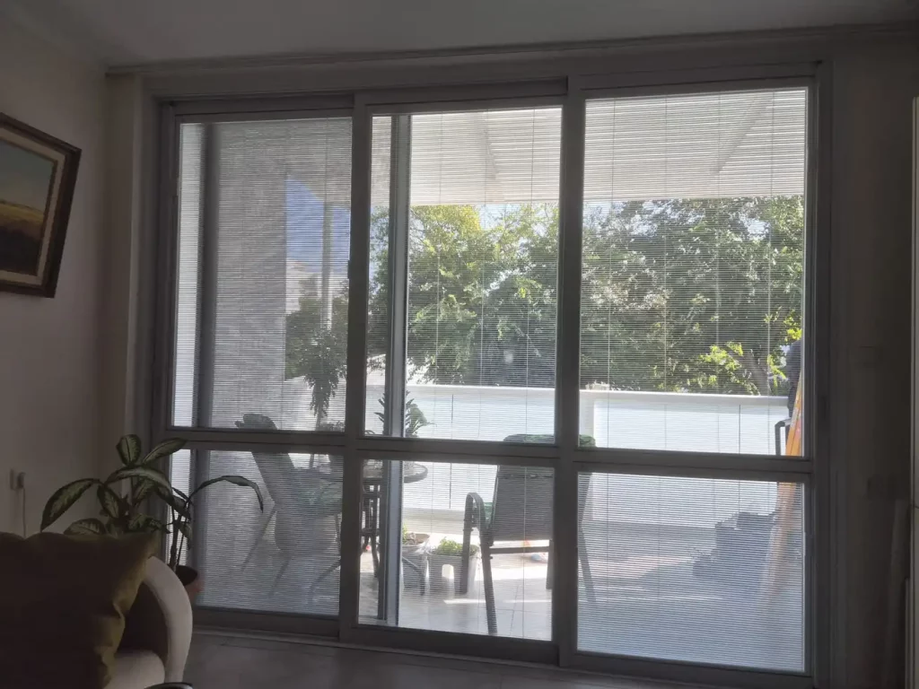 דלת הזזה מאלומיניום תלת כנפית עם תריסונים מובנים ויציאה לפטיו